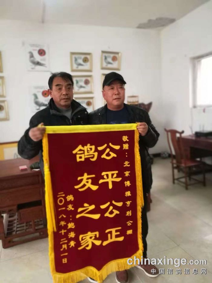 丰台鸽友鲍海清给北京博雅亨利公棚送来锦旗,并和公棚谭经理合影.